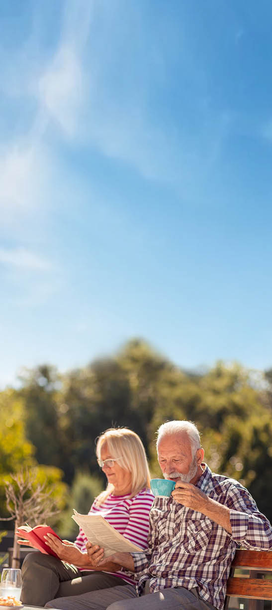An elderly couple sits on a bench, enjoying a cup of coffee together. AI generated content